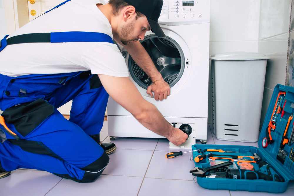 The young handsome repairman in worker suit with the professiona