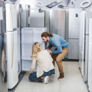 refrigerators man and woman looking at fridges at appliance store refrigerators