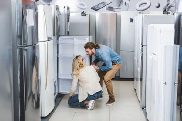 refrigerators man and woman looking at fridges at appliance store refrigerators